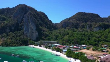 Turistler güneşli bir günde turkuaz suyu ve kireçtaşı kayalıkları olan tropikal bir cennette tekne kullanırlar. İHA alçalıyor 