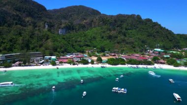 Turkuaz su, doğanın güzelliğini gösteren bir tatil köyü olan tropikal bir adayı çevrelemektedir. uçuş üstü insansız hava aracı 