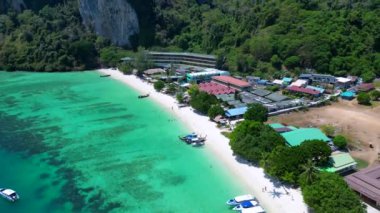 Turistler güneşli bir günde turkuaz suyu ve kireçtaşı kayalıkları olan tropikal bir cennette tekne kullanırlar. İHA alçalıyor 