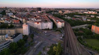 Berlin Innsbrucker Platz 'ın hava görüntüsü. Gün batımında şehir manzarasını kesen yüksek tren rayları var. hız rampası Hiperlapse hızlandırılmış zaman aşımı 