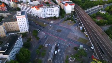 Berlin Innsbrucker Platz 'ın hava görüntüsü. Gün batımında şehir manzarasını kesen yüksek tren rayları var. panorama yörünge dronu 