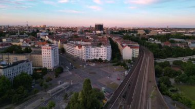 Berlin Innsbrucker Platz 'ın hava görüntüsü. Gün batımında şehir manzarasını kesen yüksek tren rayları var. Yukarıdan insansız hava aracı görüntüleri 