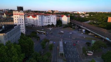 Berlin Innsbrucker Platz 'ın hava görüntüsü. Gün batımında şehir manzarasını kesen yüksek tren rayları var. İHA yükseliyor 