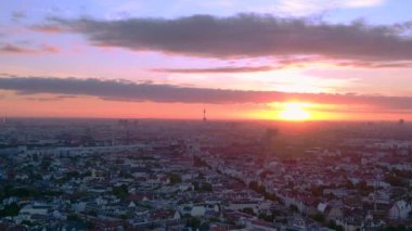 Berlin alacakaranlıkta evlerin üzerinde fernsehturm ve dramatik günbatımı ile gökyüzü, Almanya. Yukarıdan insansız hava aracı görüntüleri 