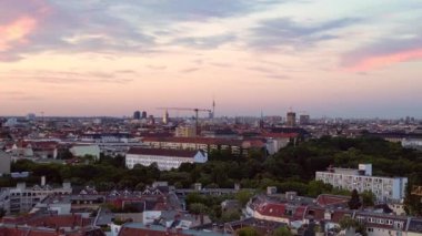 Güneş, Berlin şehrinin üzerinde batıyor. Binalara, Funkturm Kulesi 'ne ve aşağıdaki sokaklara sıcak bir ışıltı saçıyor. İHA yükseliyor 