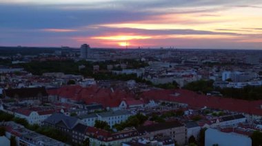 Güneş, Berlin şehrinin üzerinde batıyor. Binalara, Funkturm Kulesi 'ne ve aşağıdaki sokaklara sıcak bir ışıltı saçıyor. İHA alçalıyor 