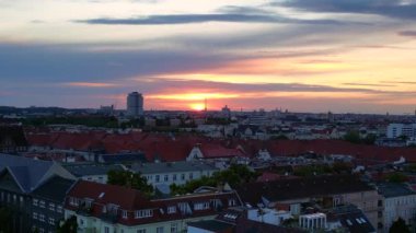 Güneş, Berlin şehrinin üzerinde batıyor. Binalara, Funkturm Kulesi 'ne ve aşağıdaki sokaklara sıcak bir ışıltı saçıyor. Ters İHA uçuşu 