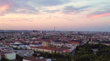Güneş, Berlin şehrinin üzerinde batıyor. Binalara, Funkturm Kulesi 'ne ve aşağıdaki sokaklara sıcak bir ışıltı saçıyor. Ters İHA uçuşu 