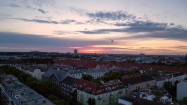 Güneş, Berlin şehrinin üzerinde batıyor. Binalara, Funkturm Kulesi 'ne ve aşağıdaki sokaklara sıcak bir ışıltı saçıyor. Ters İHA uçuşu 