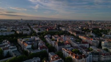 Berlin 'de gün batımında bir tren ve arabalarla geçen bir otobanın görüntüsü. Sağ drona döndür 