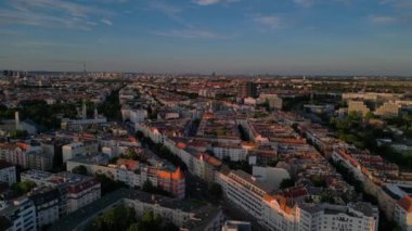Berlin 'de gün batımında bir tren ve arabalarla geçen bir otobanın görüntüsü. Sağ drona döndür 