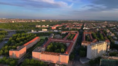 Berlin 'de gün batımında bir tren ve arabalarla geçen bir otobanın görüntüsü. Sağ drona döndür 