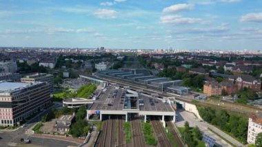 Güneşli bir yaz gününde şehir merkezini banliyöye bağlayan modern bir tren istasyonunun havadan görüntüsü. geniş yörünge görünümü dronu 