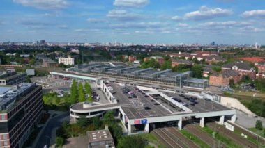 Güneşli bir yaz gününde şehir merkezini banliyöye bağlayan modern bir tren istasyonunun havadan görüntüsü. panorama yörünge dronu 