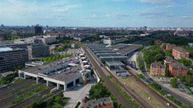 Güneşli bir yaz gününde şehir merkezini banliyöye bağlayan modern bir tren istasyonunun havadan görüntüsü. İHA yükseliyor 