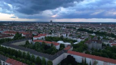 Günbatımında bulutlu bir gökyüzünün altında konut binaları, bir otoyol ve yemyeşil alanlar ile modern Avrupa şehir manzarası. hız rampası hiper hareket zaman aşımı 