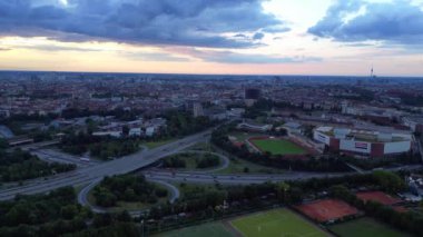 Yoğun kentsel manzarayla çevrili yeşil spor sahalarının hava görüntüsü batan güneşin sahne üzerine sıcak bir parıltı saçıyor. hız rampası hiper hareket zaman aşımı 