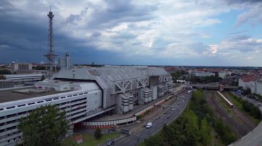 Berlin silueti ikonik radyo kulesi Funkturm 'u ve sergi alanlarını sergiliyor, tarih ve modernliğin şehir harmanını yakalıyor. İticileri ileri çalıştır 