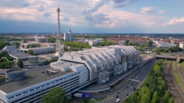 Berlin silueti ikonik radyo kulesi Funkturm 'u ve sergi alanlarını sergiliyor, tarih ve modernliğin şehir harmanını yakalıyor. Sağ drona döndür 