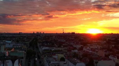 Berlin 'in bulutlu güneş doğarken hava görüntüsü. Televizyon kulesi renkli gökyüzüne karşı dikiliyor. İHA yükseliyor 