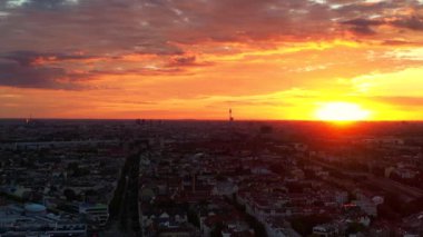 Berlin 'in bulutlu güneş doğarken hava görüntüsü. Televizyon kulesi renkli gökyüzüne karşı dikiliyor. İHA alçalıyor 