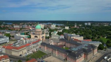 Almanya 'nın Brandenburg şehrinde güneşli bir yaz gününde tarihi binalar ve arka planda havel nehri ile Potsdam şehir merkezinin hava manzarası. İHA alçalıyor 