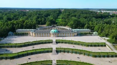 Potsdam Sanssouci Sarayı 'nın hava manzarası güneşli bir yaz gününde güzel yeşil bahçeleri ve çevreyi gösteriyor. Ters İHA uçuşu 