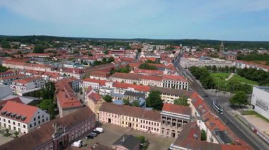 Güneşli ve bulutlu bir günde etrafını çevreleyen kırmızı çatıları ve yeşil ağaçları olan Potsdam şehir merkezinin hava manzarası. panorama genel görünüm dronu 