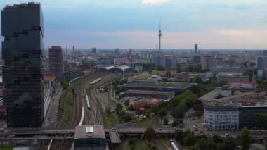 Berlin İstasyonu 'nun modern mimarisi ve tren raylarıyla bulutlu bir yaz gününde şehir merkezine giden hava manzarası. panorama genel görünüm dronu 