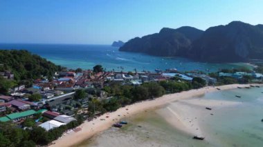 Turistler, Tayland 'daki Koh Phi Phi adası loh dalum plajında gelgitin tadını çıkarıyorlar. Uzun kuyruklu botlar dinleniyor. panorama genel görünüm dronu 