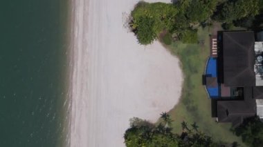 Turkuaz okyanus suyuyla buluşan tropikal ada sahilinin havadan görünüşü. dikey kuş bakışı dron 