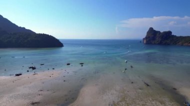 Turistler, Tayland 'daki Koh Phi Phi adası loh dalum plajında gelgitin tadını çıkarıyorlar. Uzun kuyruklu botlar dinleniyor. panorama genel görünüm dronu 
