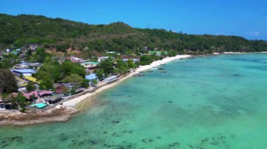 Phi phi adası korsanları plaj koyunda turkuvaz suya yanaşmış tekneler ve güneşli bir günde Tayland 'da yürüyen turistler. panorama genel görünüm dronu 