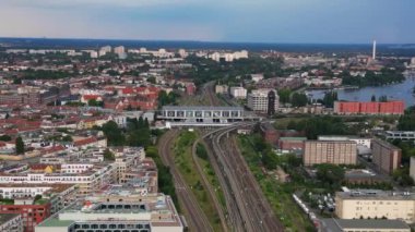 Berlin bölgesini arka plandaki nehir çılgınlığına bağlayan ostkreuz tren istasyonunun hava görüntüsü. panorama yörünge dronu 