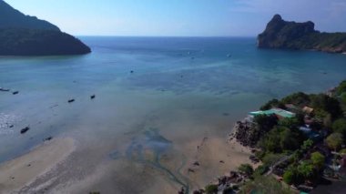Turistler, Tayland 'daki Koh Phi Phi adası loh dalum plajında gelgitin tadını çıkarıyorlar. Uzun kuyruklu botlar dinleniyor. uçuş üstü insansız hava aracı 