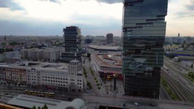 Berlin İstasyonu 'nun modern mimarisi ve tren raylarıyla bulutlu bir yaz gününde şehir merkezine giden hava manzarası. Çok yakından geçen bir insansız uçak 