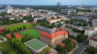 Güneşli bir yaz gününde, Emanuel Lasker Okulu Spor Sahası Berlin Şehri 'nin nehri manzarası. panorama yörünge dronu 