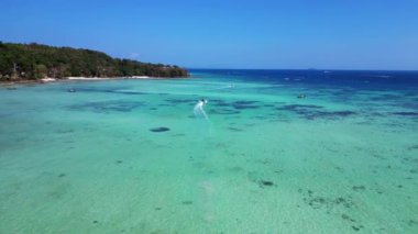 Geleneksel Tayland uzun kuyruklu teknesi turkuaz suda, tropikal ada Koh Phi Tayland 'da ve açık gökyüzünde. Ters İHA uçuşu 