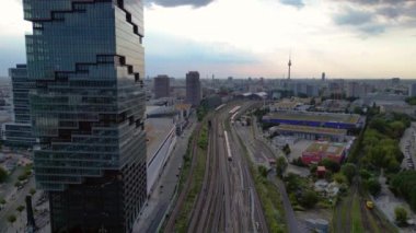 Berlin İstasyonu 'nun modern mimarisi ve tren raylarıyla bulutlu bir yaz gününde şehir merkezine giden hava manzarası. İHA yükseliyor 