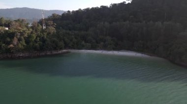 Turistler, Malezya 'daki yemyeşil tropikal ormanlarla kumlu kafatası sahillerinde dinleniyorlar. hız rampası hiper hareket zaman aşımı 