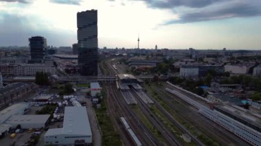 Berlin Warschauer istasyonu, birden fazla tren yolu, modern gökdelenler ve arka planda ikonik televizyon kulesi. Sağ drona döndür 