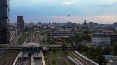 Berlin Warschauer istasyonu, birden fazla tren yolu, modern gökdelenler ve arka planda ikonik televizyon kulesi. İticileri ileri çalıştır 
