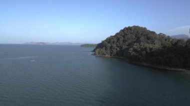 Turistler, Malezya 'daki yemyeşil tropikal ormanlarla kumlu kafatası sahillerinde dinleniyorlar. panorama genel görünüm dronu 