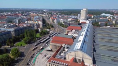 Leipzig Opera Salonu 'nun ve merkez istasyonunun hava görüntüsü güneşli bir yaz gününde tramvay ve otobüslerin sürüşünü gösteriyor. panorama genel görünüm dronu 