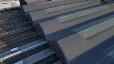 Leipzig merkez istasyonu, güzel çelik mimariyi ve şehir siluetini gösteren tren geliyor. Drone 'u yukarı eğ 