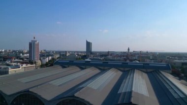 Leipzig merkez istasyonu, güzel çelik mimariyi ve şehir siluetini gösteren tren geliyor. Ters İHA uçuşu 