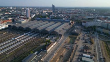 Leipzig merkez istasyonu, güzel çelik mimariyi ve şehir siluetini gösteren tren geliyor. İHA alçalıyor 