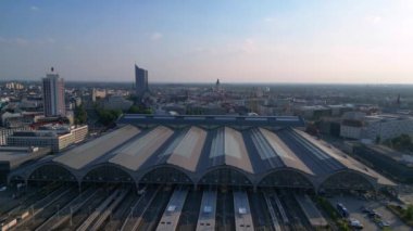 Leipzig merkez istasyonu, güzel çelik mimariyi ve şehir siluetini gösteren tren geliyor. geniş yörünge görünümü dronu 