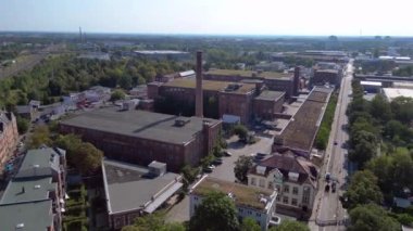 Hava perspektifi Leipzig pamuk fırıldak fabrikası endüstriyel mimarisi sergiliyor, tuğla binalar ve belirgin bir bacayla karakterize ediliyor. panorama yörünge dronu 