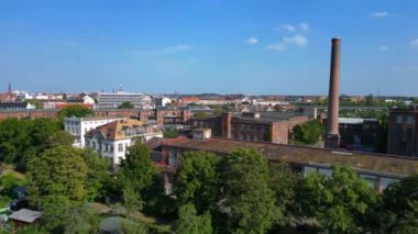 Hava perspektifi Leipzig pamuk fırıldak fabrikası endüstriyel mimarisi sergiliyor, tuğla binalar ve belirgin bir bacayla karakterize ediliyor. İHA yükseliyor 